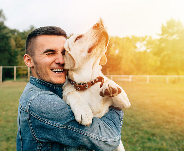 Man with his pet dog happy after pet dander allergy treatment